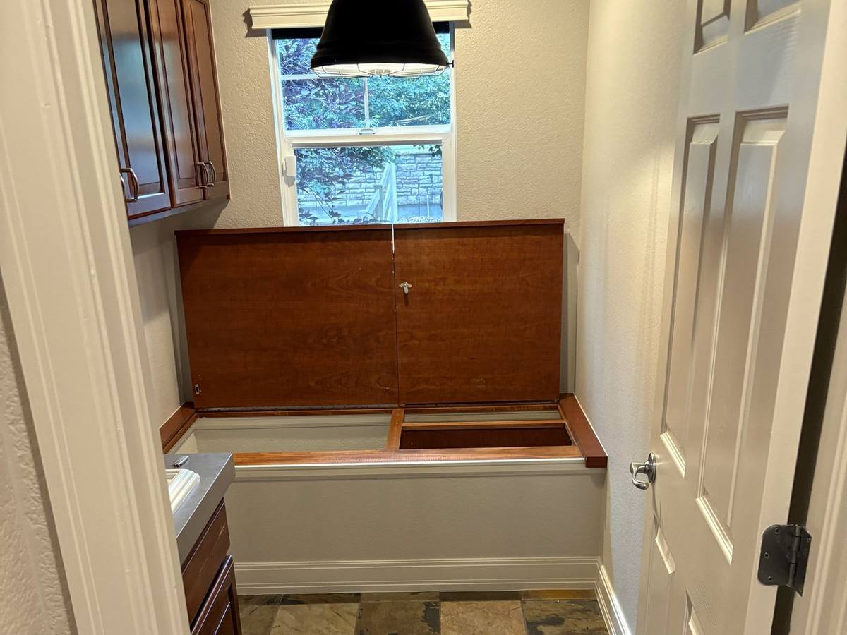 Laundry room with cabinets, sink, and slate tile before the gut