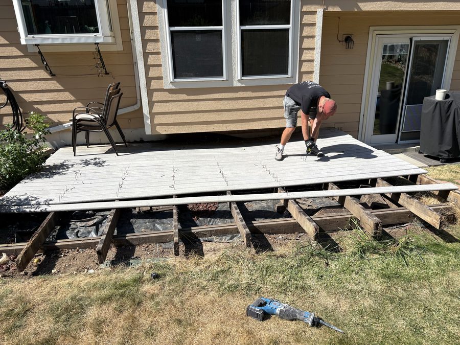 Composite deck boards being pulled off the joists during a deck demolition in Arvada, Colorado