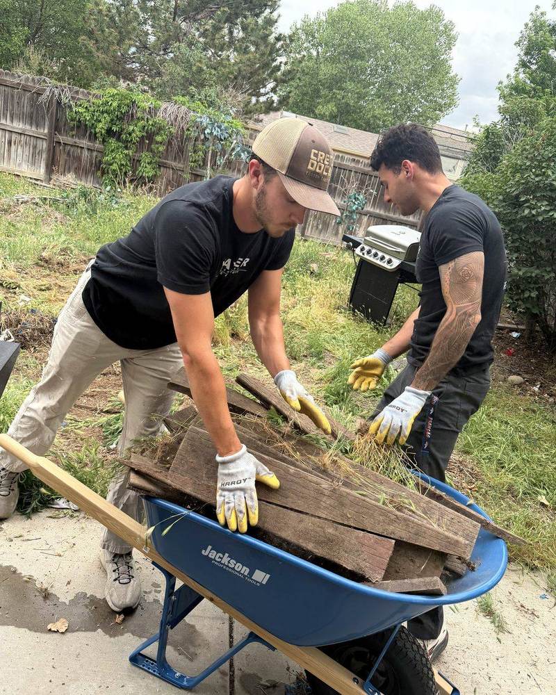 Mayer Enterprises crew loading lumber into a wheelbarrow in Denver
