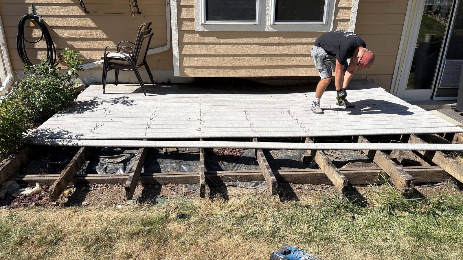 Mayer Enterprises crew pulling composite deck boards off the joists on a demolition job in Arvada, Colorado