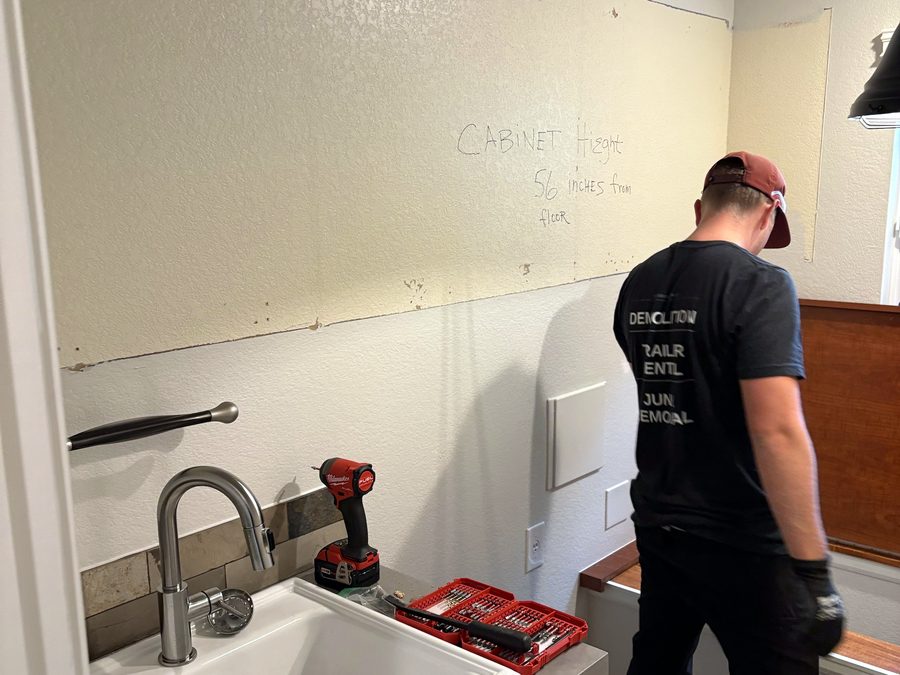 Cabinets out and tile removal underway during a laundry room gut in Golden, Colorado