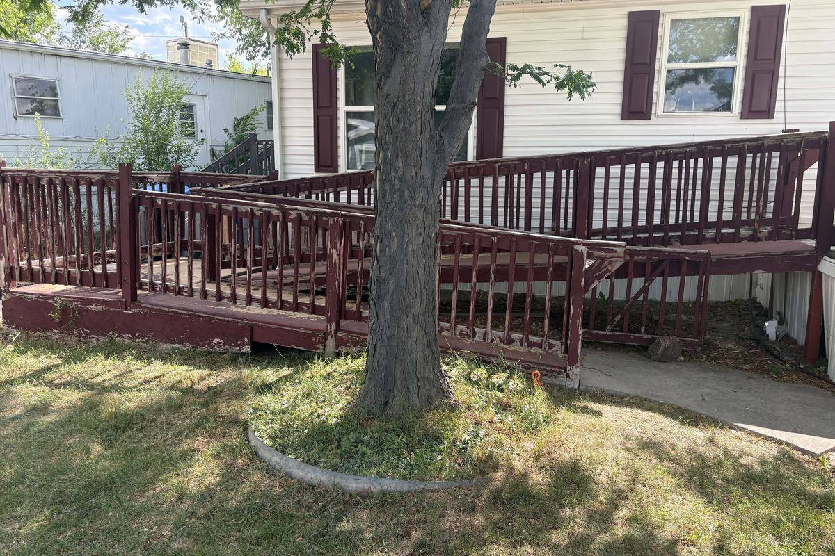 Wooden wheelchair ramp wrapped around a manufactured home in Golden before removal